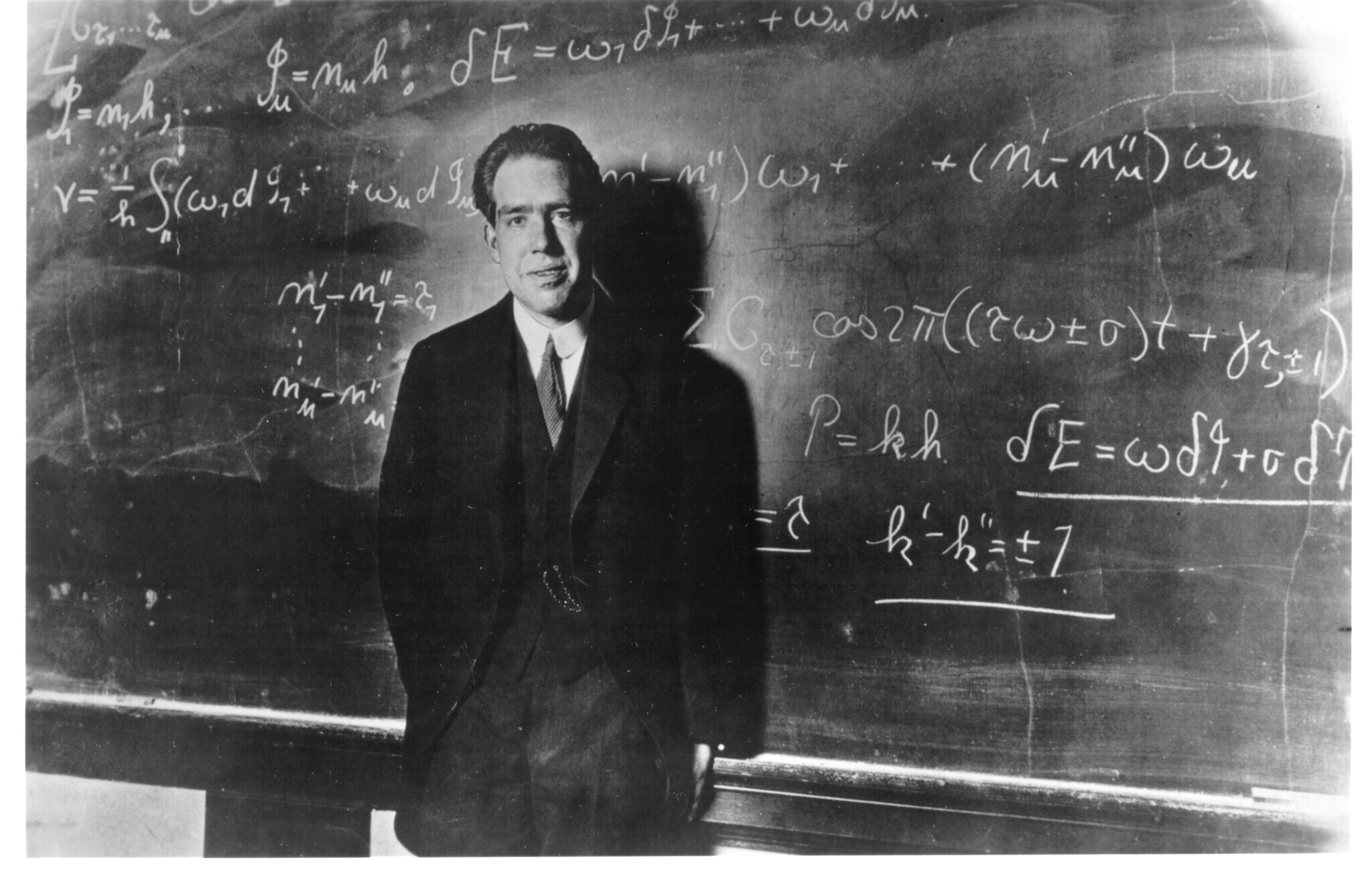 Niels Bohr as a younger man, at a chalkboard.