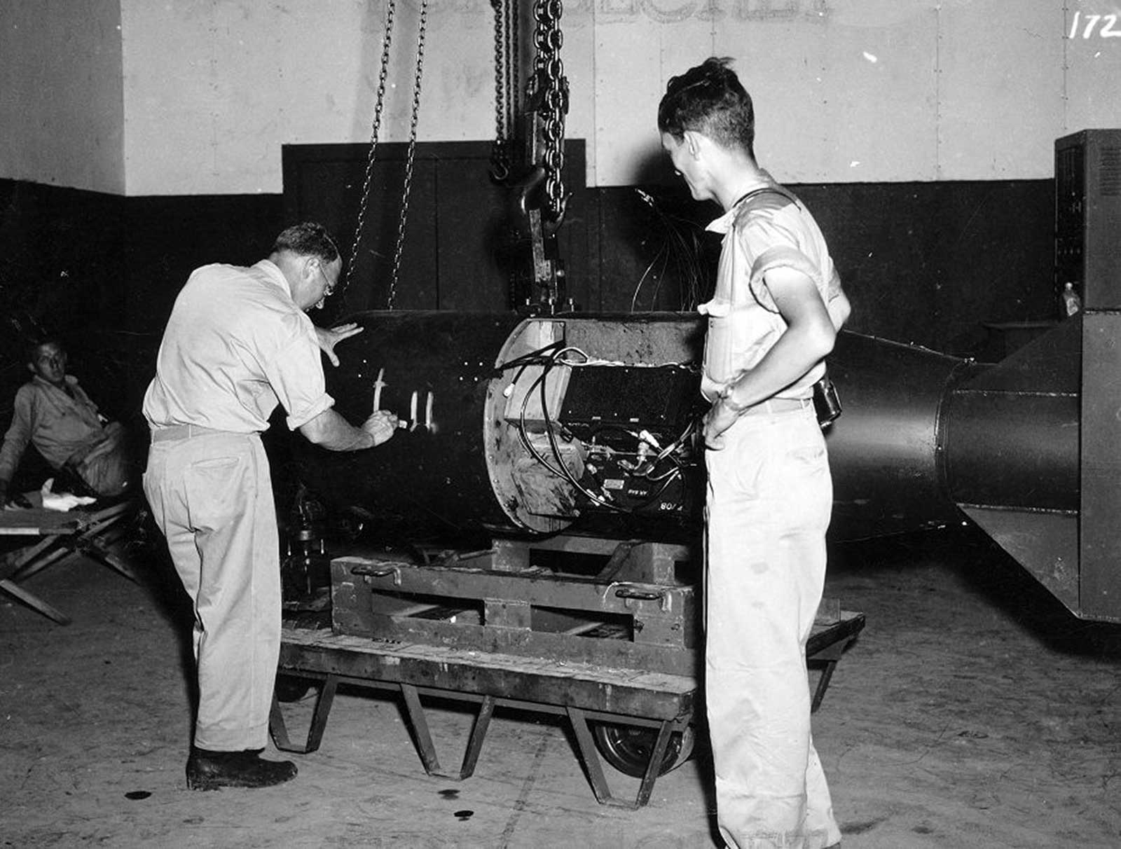 Project A (Alberta) member CDR A. Francis Birch (left) numbers Little Boy Unit L-11 while Norman Ramsey (right) watches.